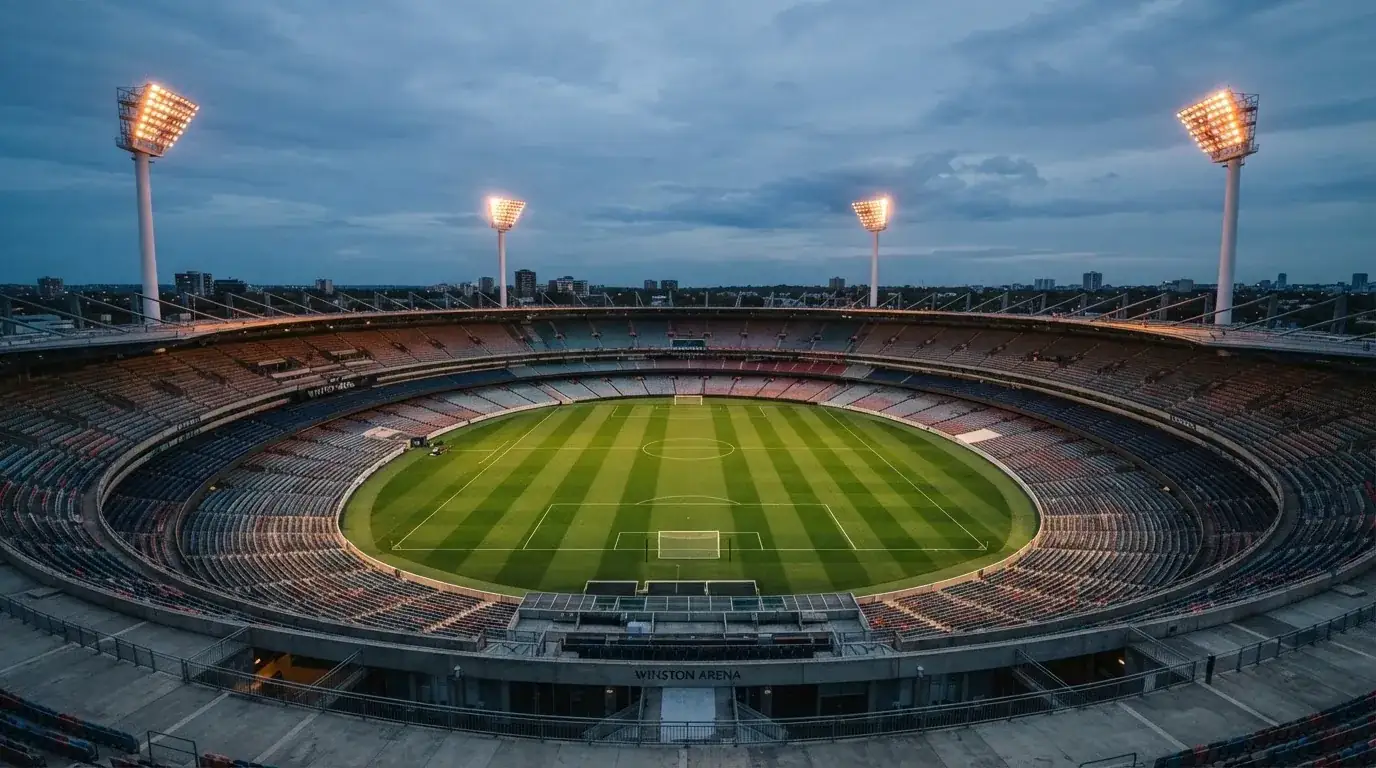 An empty football stadium with floodlight masts at dusk