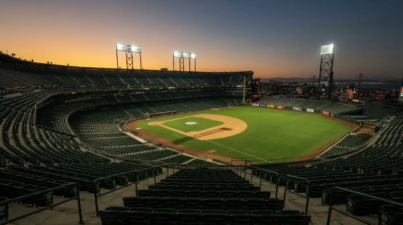 An empty football stadium with floodlight masts at dusk