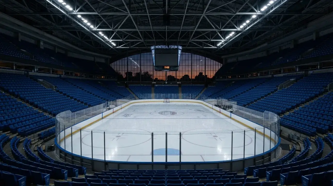 An empty football stadium with floodlight masts at dusk